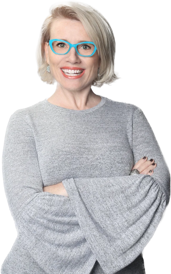Professional headshot of Dr. Shannon Coates, a vocal pedagogy expert and Substack author, wearing bright teal glasses and smiling.